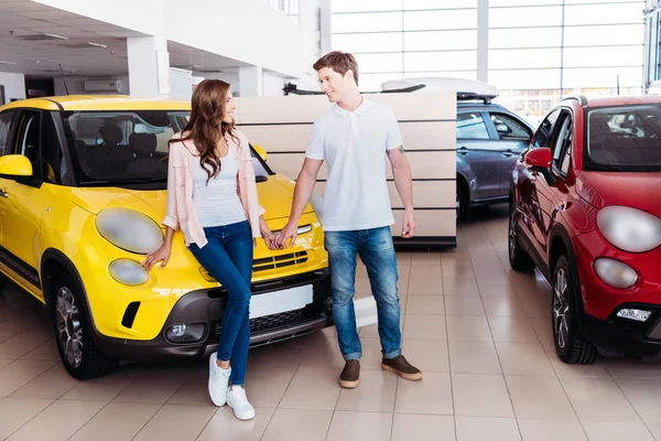 Pareja cogida de la mano delante del coche - foto de stock