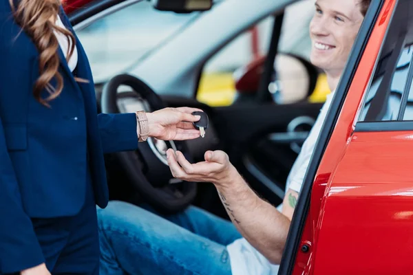 Gerente dando la llave del coche al cliente - foto de stock