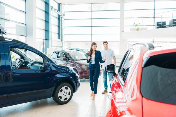 Sales manager showing car to customer — Stock Photo
