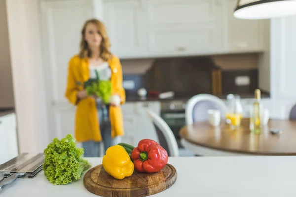 Woman with red and yellow peppers — Stock Photo