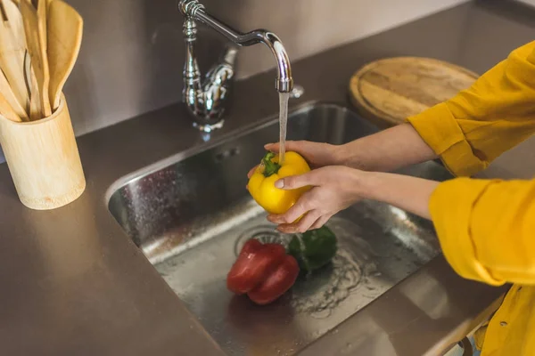 Mujer lavando pimiento rojo - foto de stock