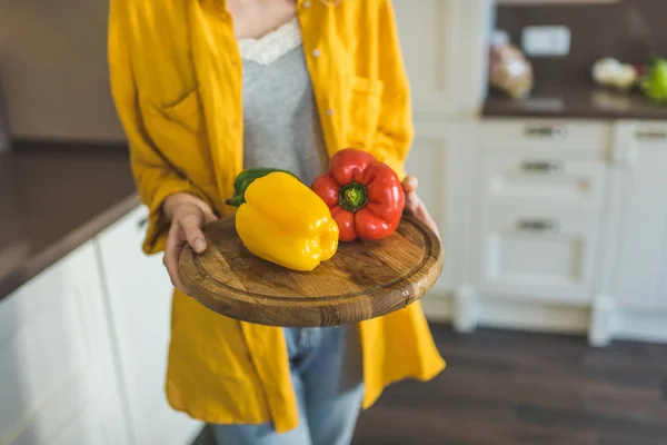 Woman with red and yellow peppers — Stock Photo