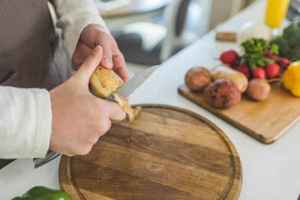 El hombre rebanando patatas - foto de stock