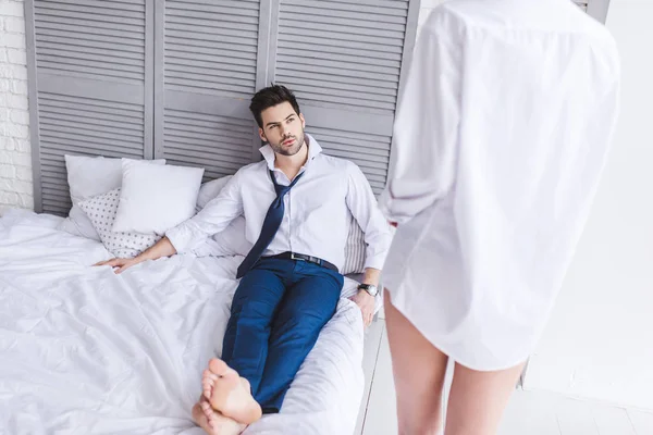 Schnappschuss eines gutaussehenden Mannes, der auf dem Bett liegt und Freundin ansieht — Stockfoto