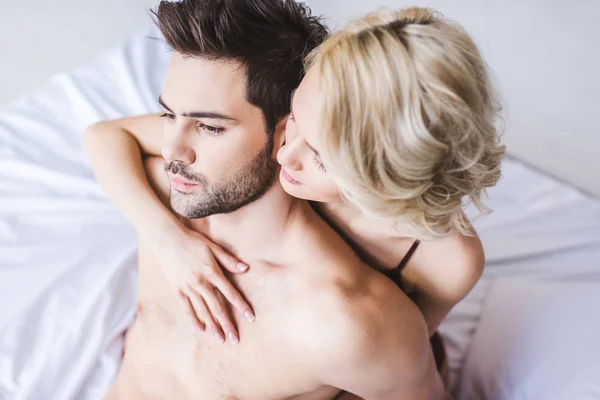 Vue grand angle de beau couple sensuel étreignant sur le lit — Photo de stock