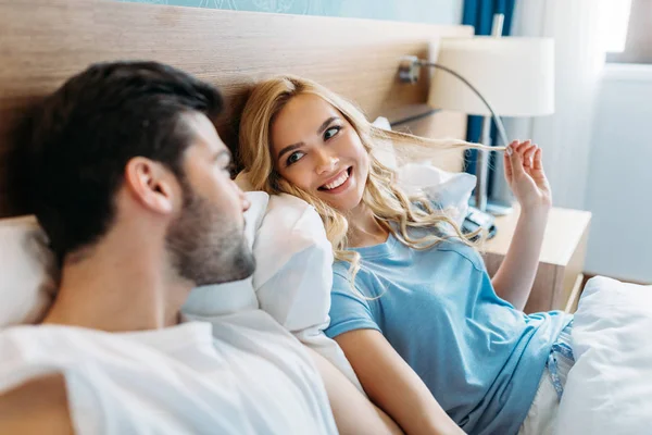 Sorrindo casal olhando um para o outro na cama — Fotografia de Stock