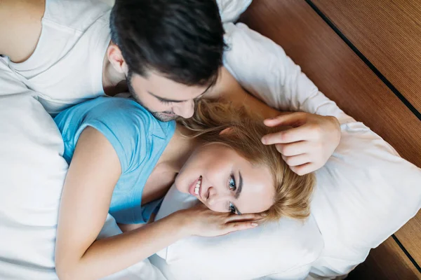 Blick über den Kopf: Freund berührt Freundin morgens im Bett an den Haaren — Stockfoto
