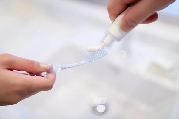 Cropped image of boyfriend applying tooth paste on girlfriend tooth brush — Stock Photo