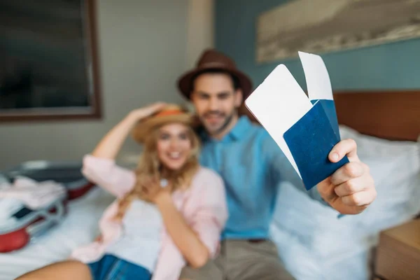 Casal sorridente no quarto de hotel com passaportes com bilhetes em primeiro plano — Fotografia de Stock