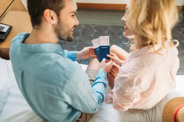 Vue grand angle du couple souriant tenant des passeports et des billets pour le voyage — Photo de stock