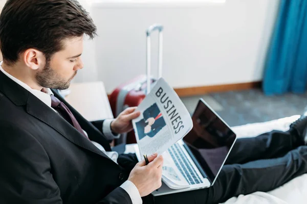 Hombre de negocios leyendo periódico en habitación de hotel - foto de stock