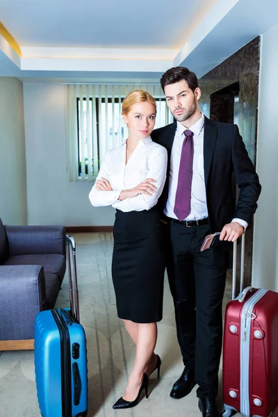 Homme d'affaires et femme d'affaires avec passeports et billets dans le couloir de l'hôtel — Photo de stock