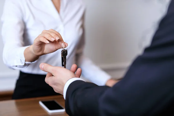 Image recadrée de la réceptionniste donnant la clé au client à l'hôtel — Photo de stock