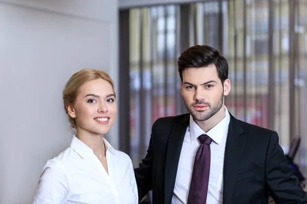 Hombre de negocios y mujer de negocios de pie en recepción en el hotel - foto de stock