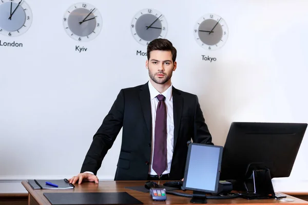 Handsome receptionist standing at reception desk in hotel — Stock Photo