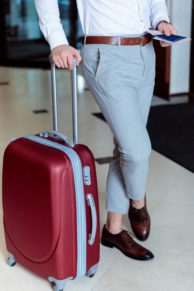 Обрезанное изображение туриста с дорожной сумкой и паспортом — стоковое фото