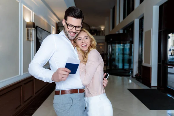 Smiling couple of tourists hugging in hotel — Stock Photo