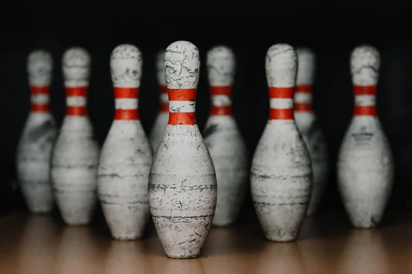 Close-up shot of grungy bowling pins in gate on black — Stock Photo