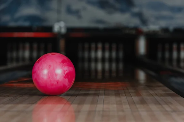 Gros plan de boule de bowling rouge couchée sur l'allée — Photo de stock