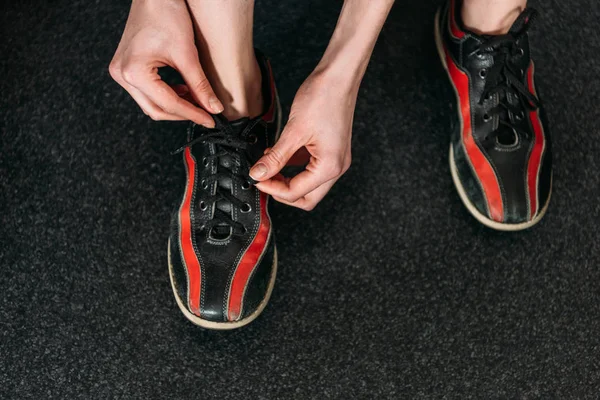 Cropped shot of woman tying up rental bowling shoes — Stock Photo