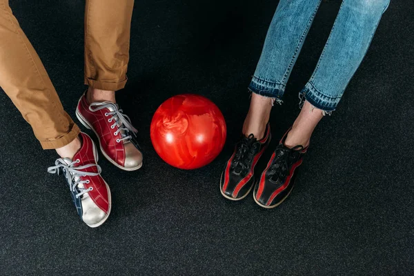 Обрезанный снимок пары в арендованной обуви для боулинга с мячом — стоковое фото