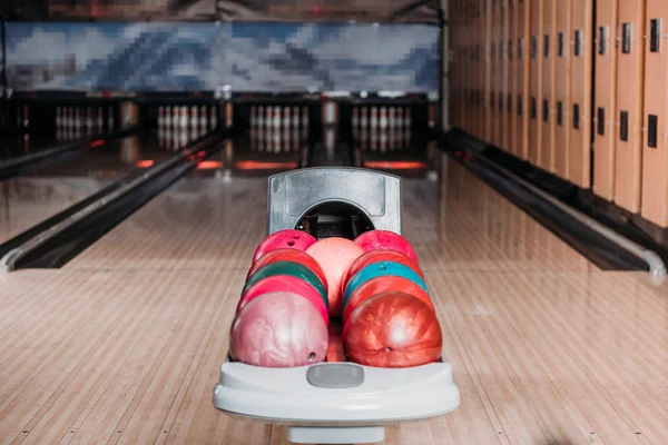 Stand avec des boules de bowling colorées dans le club contre les ruelles — Photo de stock