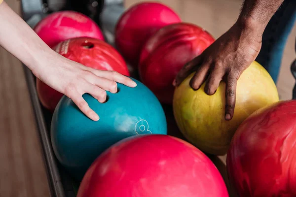 Schnappschuss von Mann und Frau, die Bowlingbälle vom Ständer nehmen — Stockfoto