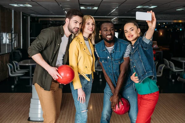 Felici giovani amici che prendono selfie insieme al bowling club — Foto stock