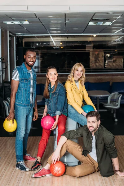 Group of young friends posing with balls together at bowling club — Stock Photo