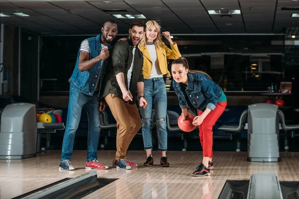 Gruppo eccitato di giovani amici che giocano a bowling insieme — Foto stock