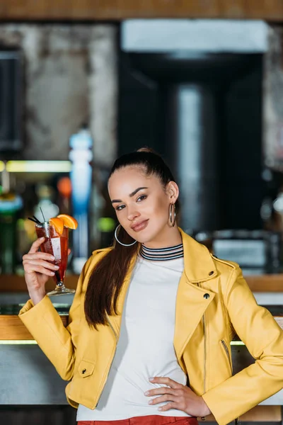 Красива молода жінка з коктейлем проводить час у барі — стокове фото