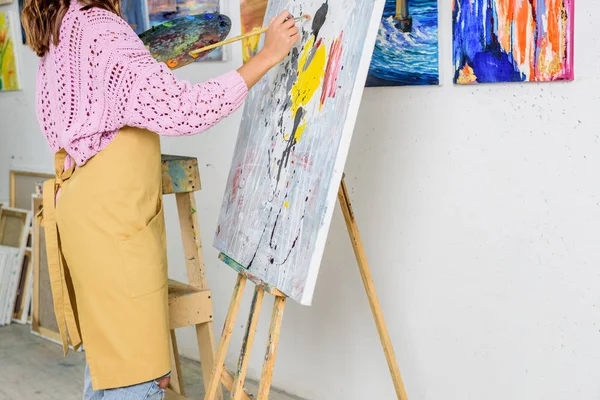 Cropped image of female artist painting with brush in workshop — Stock Photo