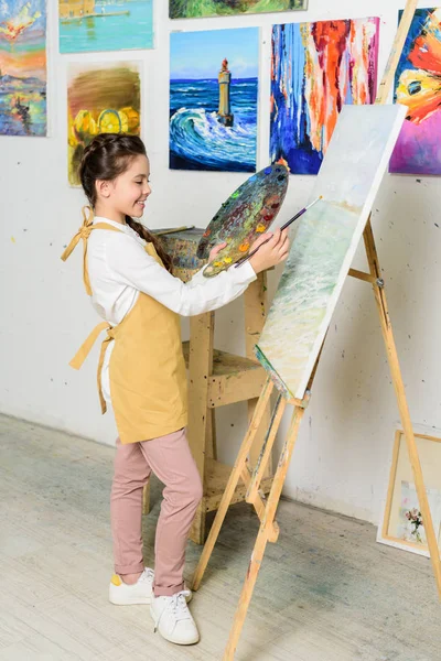 Side view of preteen kid painting in workshop of art school — Stock Photo