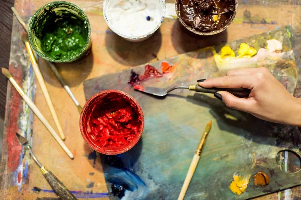 Zugeschnittenes Bild des Künstlers, der in der Werkstatt Farbe auf Palette aufträgt — Stockfoto