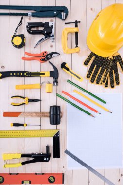 Top view of different tools with blueprint on wooden tabletop clipart