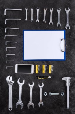 Top view of set of construction tools, smartphone and blank clipboard clipart