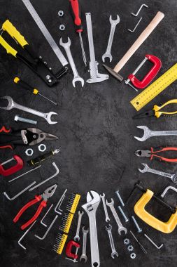 Top view of set of construction tools on black background