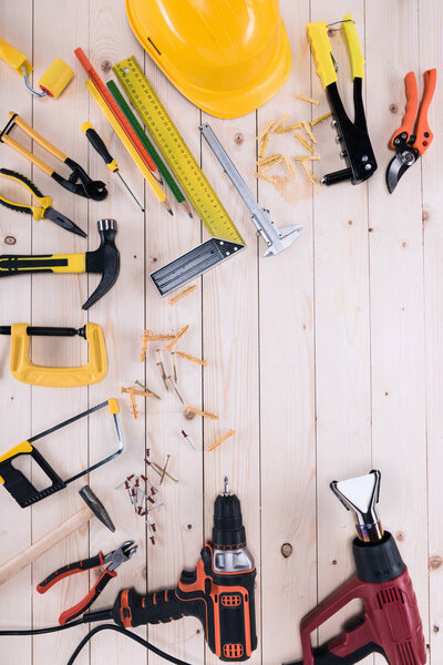 Top view of different tools on wooden tabletop with copy space