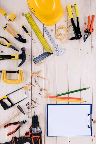 Top view of different tools with clipboard on wooden tabletop with copy space — Stock Photo, Image