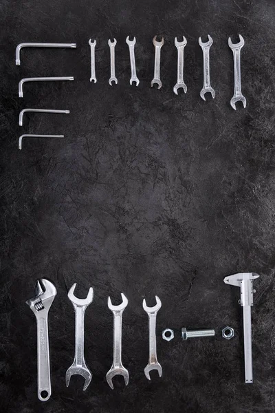 Top view of set of construction tools, wrenches and spanners on black — Stock Photo, Image