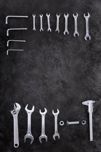 Top view of set of construction tools, wrenches and spanners on black