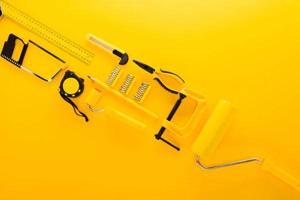 Top view of various work tools and ruler on yellow — Stock Photo, Image