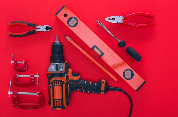 Top view of various work tools and pencil on red — Stock Photo, Image