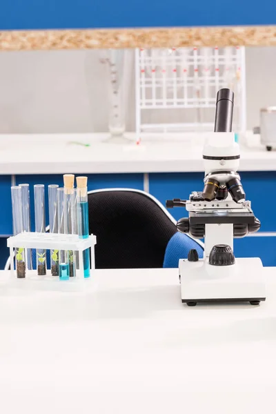 Tubes and microscope in laboratory — Stock Photo, Image