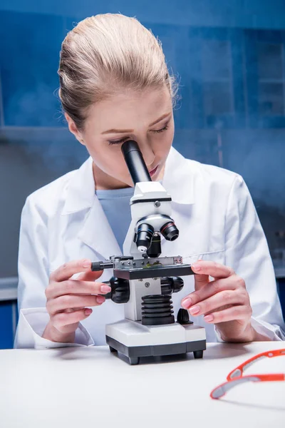 Attractive scientist working with microscope — Stock Photo, Image