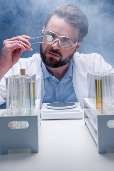 chemist in goggles with reagents