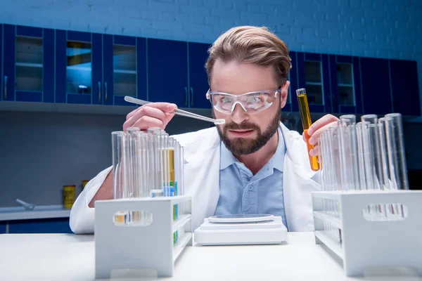 Chemist in goggles with reagents — Stock Photo, Image