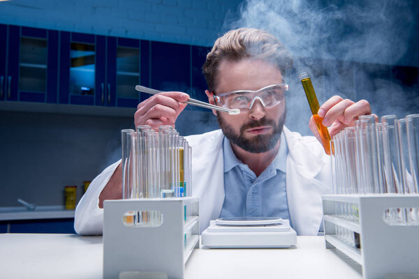 chemist in goggles with reagents