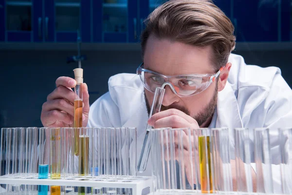 Chemist in goggles with reagents — Stock Photo, Image