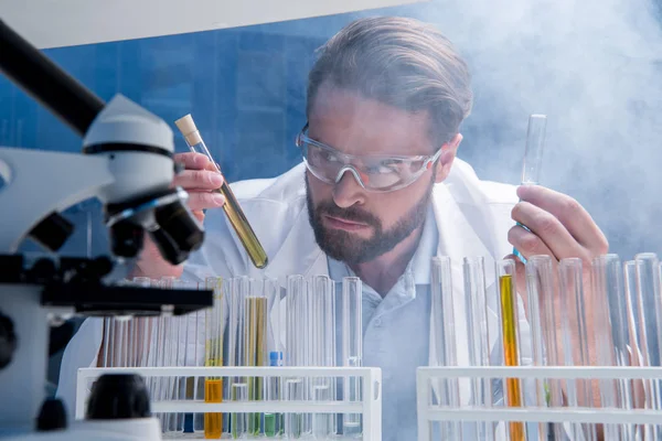 Chemist in goggles with reagents — Stock Photo, Image